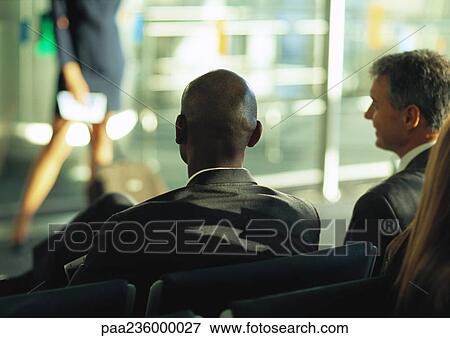 Businessmen sitting and looking at blurred woman in the distance. View Large Photo Image Stock Photo - Businessmen sitting and looking at blurred woman in the distance.. Fotosearch