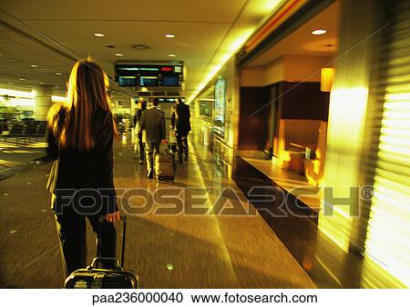 Businesswoman pulling suitcase through airport terminal. View Large Photo Image Stock Image - Businesswoman pulling suitcase through airport terminal.. Fotosearch