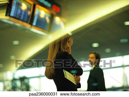 Businesswoman standing with arms crossed, businessman in background, blurred. View Large Photo Image Stock Image - Businesswoman standing with arms crossed, businessman in background, blurred.. Fotosearch