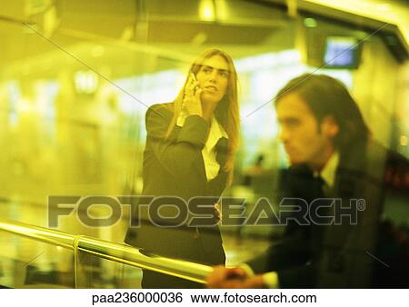 Businesswoman using cell phone with man resting hands on metal rails, blurred. View Large Photo Image Stock Photograph - Businesswoman using cell phone with man resting hands on metal rails, blurred.. Fotosearch
