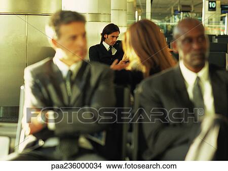 Group of business people sitting together in airport lounge View Large Photo Image Picture - Group of business people sitting together in airport lounge. Fotosearch