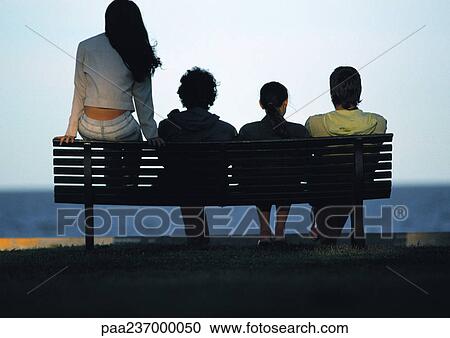 Friends sitting on bench at sunset, rear view. View Large Photo Image Stock Image - Friends sitting on bench at sunset, rear view.. Fotosearch