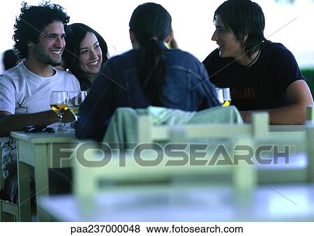 Friends talking at table. View Large Photo Image Stock Photo - Friends talking at table.. Fotosearch