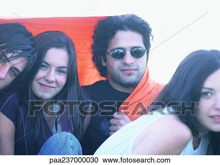 Friends wrapped in orange blanket, close-up. View Large Photo Image Stock Image - Friends wrapped in orange blanket, close-up.. Fotosearch