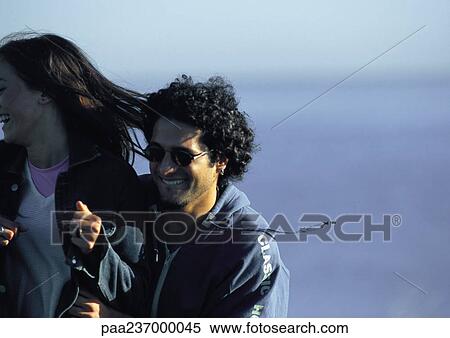 Stock Photography - Man smiling with hands on woman's waist. Fotosearch