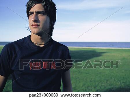 Man standing near water, looking away View Large Photo Image Stock Photo - Man standing near water, looking away. Fotosearch