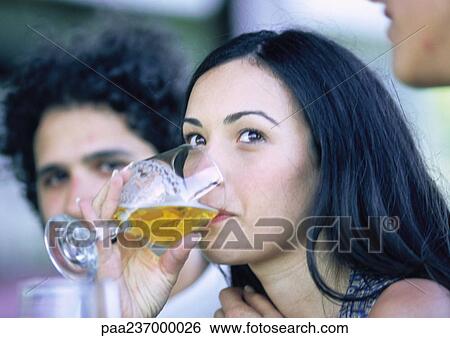 Woman drinking from glass, next to man, close-up. View Large Photo Image Stock Photograph - Woman drinking from glass, next to man, close-up.. Fotosearch