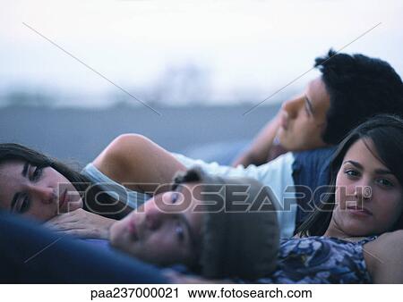Young people lying together outdoors View Large Photo Image Stock Image - Young people lying together outdoors. Fotosearch