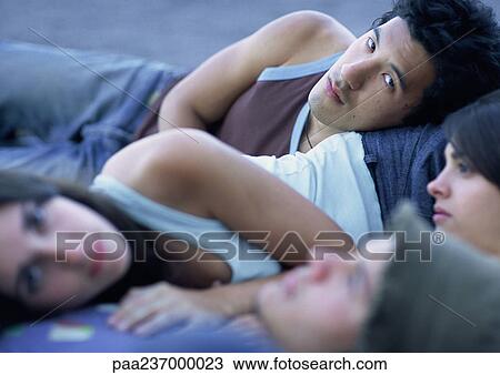 Young people lying together outdoors View Large Photo Image Stock Image - Young people lying together outdoors. Fotosearch