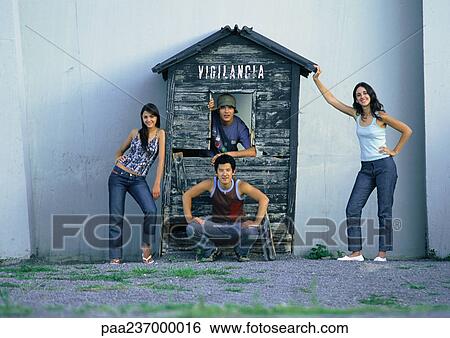 Young people posing next to wooden house facade View Large Photo Image Stock Photograph - Young people posing next to wooden house facade. Fotosearch