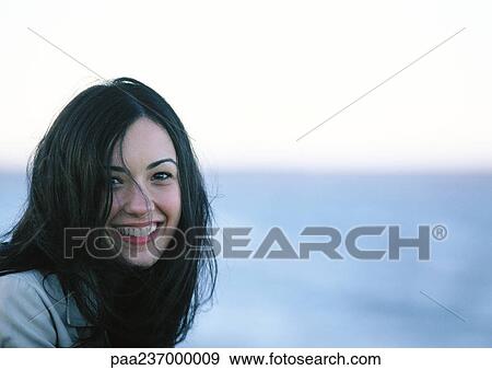 Stock Photo - Young woman smiling, close-up.. Fotosearch