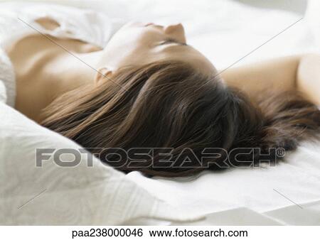 Stock Photograph - Woman lying on bed, close-up. Fotosearch