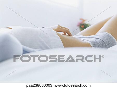 Woman lying on bed in underclothes, mid section View Large Photo Image Stock Image - Woman lying on bed in underclothes, mid section. Fotosearch