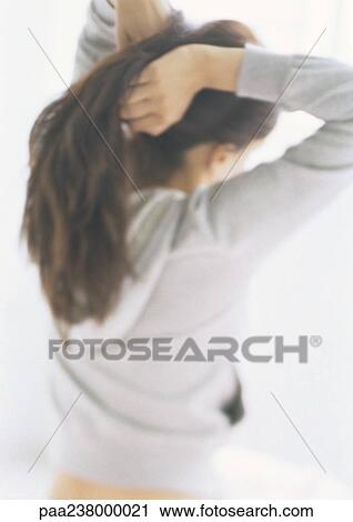 Woman pulling hair back, rear view View Large Photo Image Stock Image - Woman pulling hair back, rear view. Fotosearch