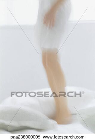 Woman standing on bed, low section, blurred View Large Photo Image Stock Photography - Woman standing on bed, low section, blurred. Fotosearch