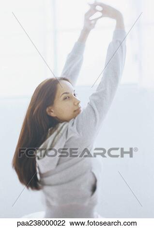 Woman stretching, looking over shoulder View Large Photo Image Stock Image - Woman stretching, looking over shoulder. Fotosearch