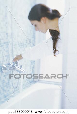 Woman turning bath faucet, blurred View Large Photo Image Stock Photo - Woman turning bath faucet, blurred. Fotosearch