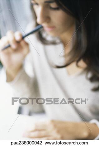 Woman with pen in mouth, blurred View Large Photo Image Stock Image - Woman with pen in mouth, blurred. Fotosearch