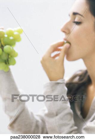Young woman eating grapes, side view, close-up View Large Photo Image Stock Photo - Young woman eating grapes, side view, close-up. Fotosearch