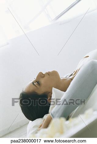 Young woman lying down, close-up View Large Photo Image Stock Photo - Young woman lying down, close-up. Fotosearch