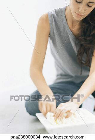 Young woman sitting with hands in dish View Large Photo Image Picture - Young woman sitting with hands in dish. Fotosearch