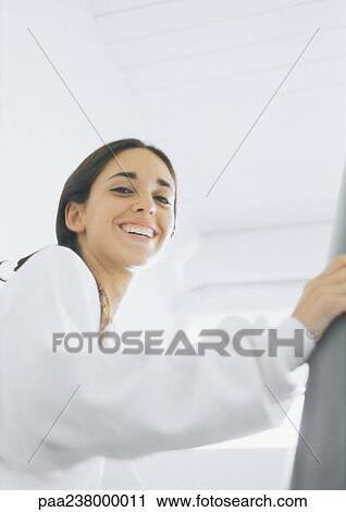 Young woman smiling, low angle view View Large Photo Image Stock Image - Young woman smiling, low angle view. Fotosearch