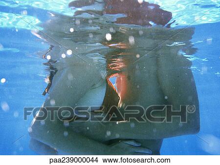 Couple embracing, mid-section, underwater view View Large Photo Image Picture - Couple embracing, mid-section, underwater view. Fotosearch