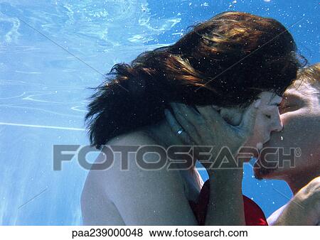 Stock Photo - Couple kissing underwater, close-up. Fotosearch