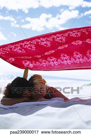 Stock Photo - Couple lying on beach. Fotosearch