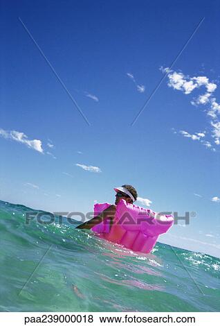 Man sitting on air mattress in sea, floating View Large Photo Image Stock Photo - Man sitting on air mattress in sea, floating. Fotosearch