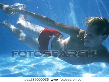 Man swimming underwater, portrait View Large Photo Image Stock Photograph - Man swimming underwater, portrait. Fotosearch