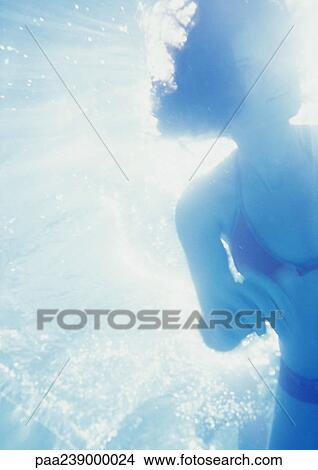 Picture - Woman underwater, low angle view. Fotosearch