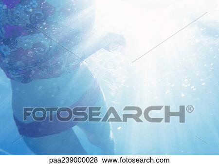 Stock Photo - Woman underwater, mid-section. Fotosearch