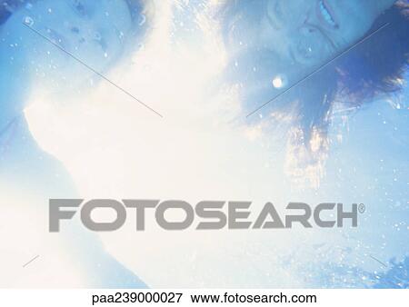 Stock Photo - Women's faces underwater, close-up. Fotosearch