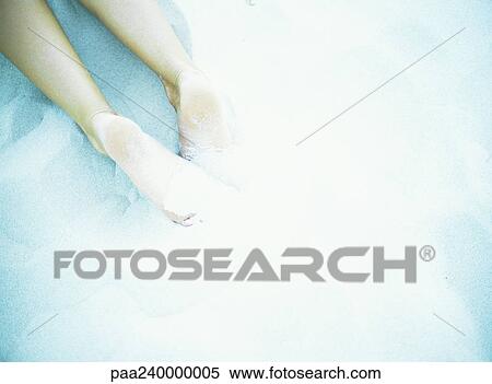 Stock Photography - Bare legs in sand, blurred. Fotosearch