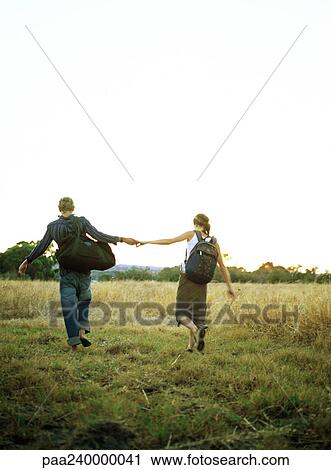 Couple holding hands in field, rear view View Large Photo Image Stock Image - Couple holding hands in field, rear view. Fotosearch