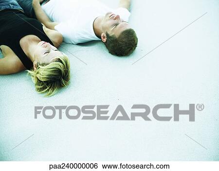 Man and woman lying side by side, elevated view View Large Photo Image Stock Photograph - Man and woman lying side by side, elevated view. Fotosearch