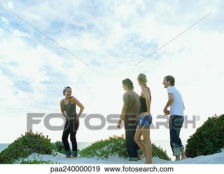 Men and women standing on sand dune View Large Photo Image Stock Photo - Men and women standing on sand dune. Fotosearch
