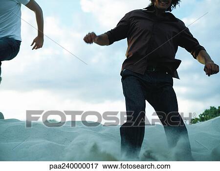 People running down sand dune, close-up View Large Photo Image Stock Photo - People running down sand dune, close-up. Fotosearch
