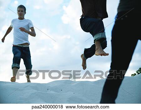 People running down sand dune, close-up View Large Photo Image Stock Photo - People running down sand dune, close-up. Fotosearch