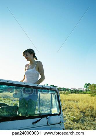 Stock Image - Woman standing up in 4x4 vehicle. Fotosearch