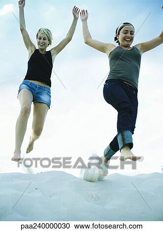 Women jumping on sand, low angle view View Large Photo Image Stock Image - Women jumping on sand, low angle view. Fotosearch