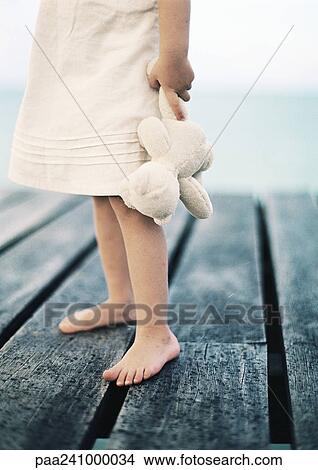 Child holding teddy bear, low section View Large Photo Image Picture - Child holding teddy bear, low section. Fotosearch