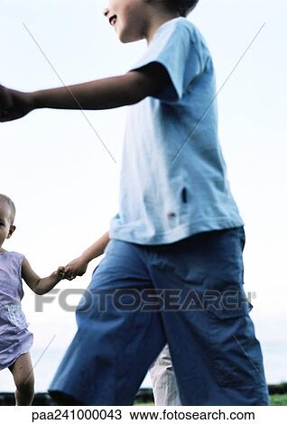 Stock Image - Children walking in ring, close-up, low angle view. Fotosearch