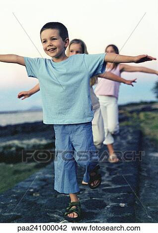 Children walking single file with arms out View Large Photo Image Stock Image - Children walking single file with arms out. Fotosearch