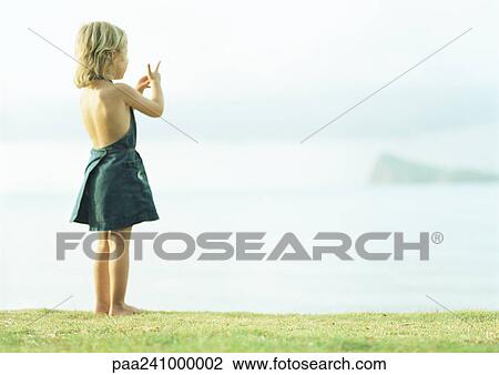 Girl standing on grass, rear view View Large Photo Image Stock Image - Girl standing on grass, rear view. Fotosearch