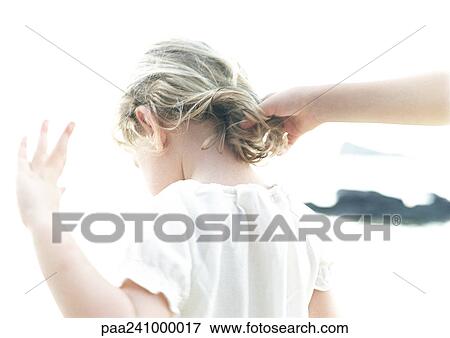 Stock Photo - Hand touching child's hair, rear view, blurred. Fotosearch