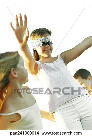 Three children, one blindfolded with arms out View Large Photo Image Picture - Three children, one blindfolded with arms out. Fotosearch