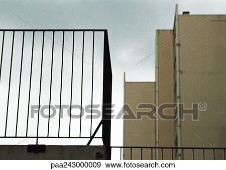 Stock Photo - View of apartment building with guard rail in foreground, low angle view. Fotosearch