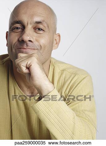 Man smiling at camera with fist against chin, close-up View Large Photo Image Stock Photography - Man smiling at camera with fist against chin, close-up. Fotosearch
